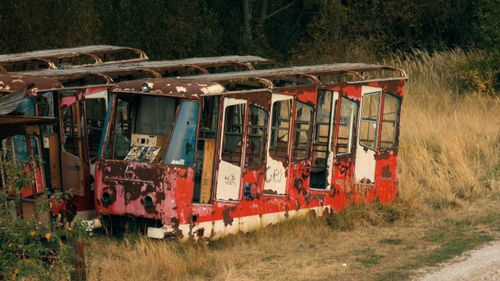 Free Rusty, graffiti-covered trams abandoned in a grassy field, Poprad, Slovakia. Stock Photo