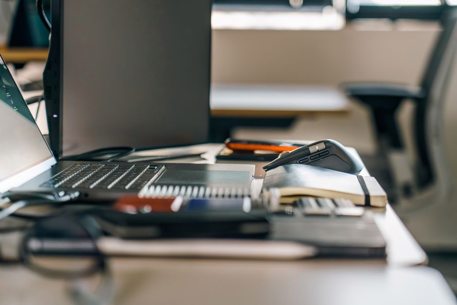 A contemporary office desk setup featuring a laptop, mouse, and other office gadgets.