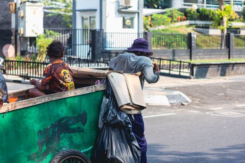 Free Two individuals collecting cardboard on a street, reflecting urban recycling efforts. Stock Photo