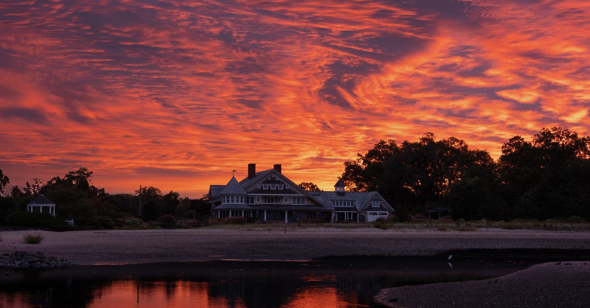 Majestic sunrise over waterfront estate in Stamford, Connecticut, showcasing vibrant skies.