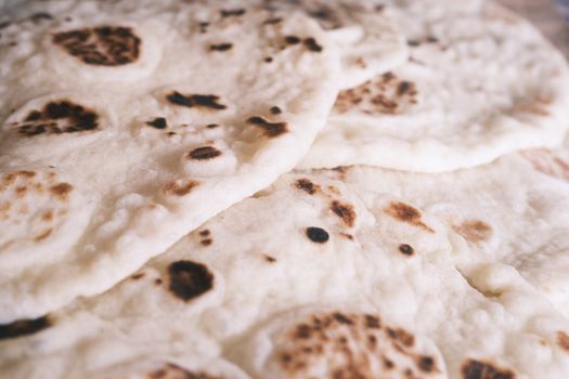 Close-up image of freshly cooked flatbreads with toasted spots, ideal for culinary use.