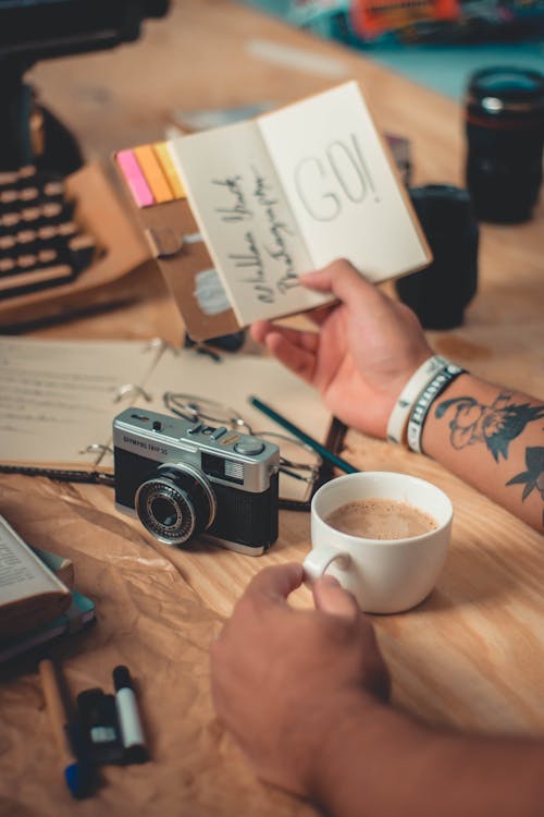 Free Person Holding Mini Notebook and Cup of Coffee Stock Photo