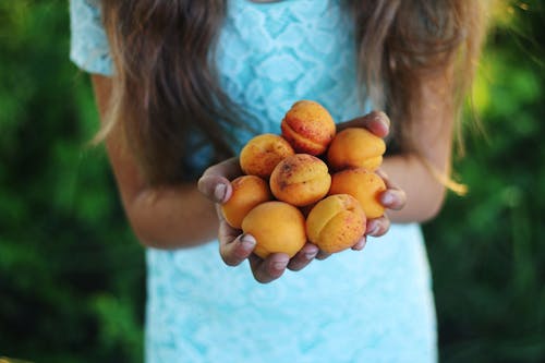 Девушка держит желтые круглые фрукты