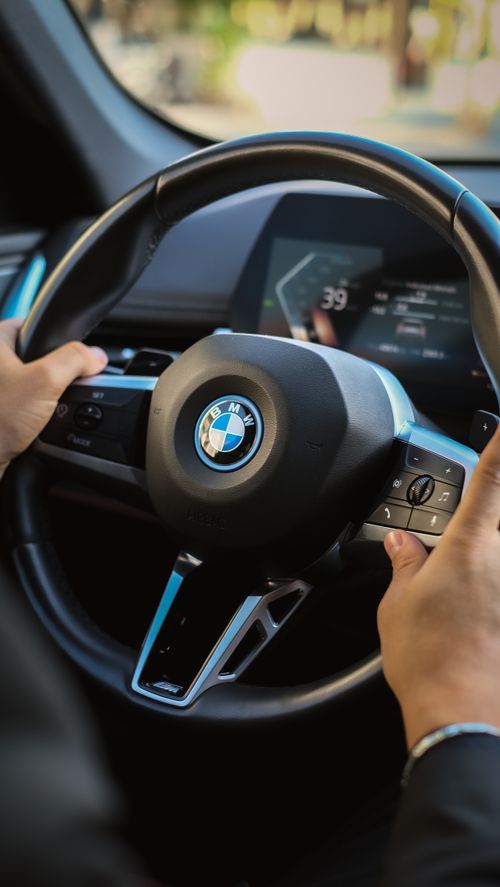 Free Interior close-up of a BMW steering wheel highlighting car features and design in a modern setting. Stock Photo