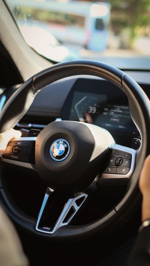 Free A driver grips the BMW steering wheel, capturing the car's luxurious interior design. Stock Photo
