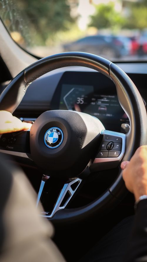 Free Close-up of BMW steering wheel with digital dashboard, showcasing modern car interior design. Stock Photo