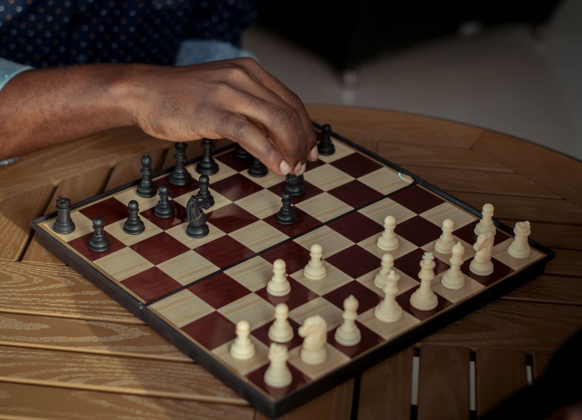 Hand moving a chess piece, representing strategic decision-making in the organic traffic playbook
