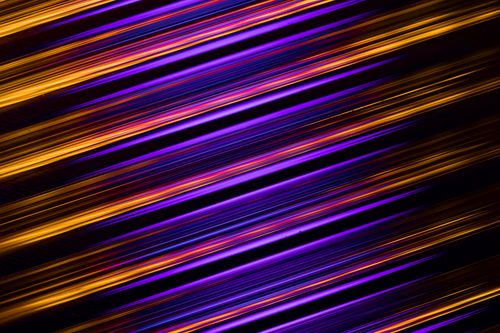 Free Dynamic abstract image featuring vibrant light streaks over a dark background, evoking speed and energy. Stock Photo