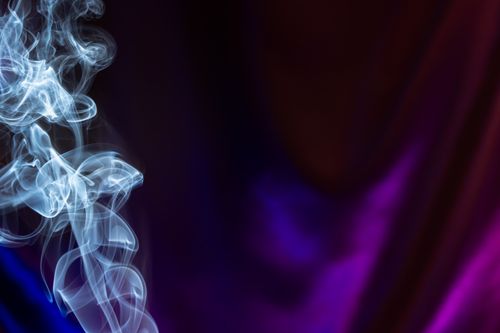 Free Captivating image of ethereal smoke swirls against a luminous purple and blue backdrop. Stock Photo