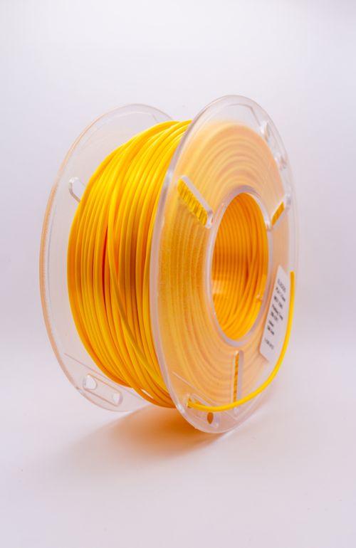 Free High-quality yellow 3D printing filament spool ready for creative projects. Stock Photo