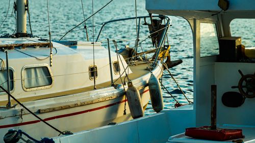 Free A serene view of a sailboat docked in İzmir harbor during sunset, capturing nautical tranquility. Stock Photo