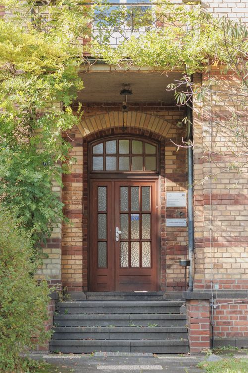 Free Elegant brick entryway in Bonn, framed by lush greenery, showcasing classic architecture. Stock Photo