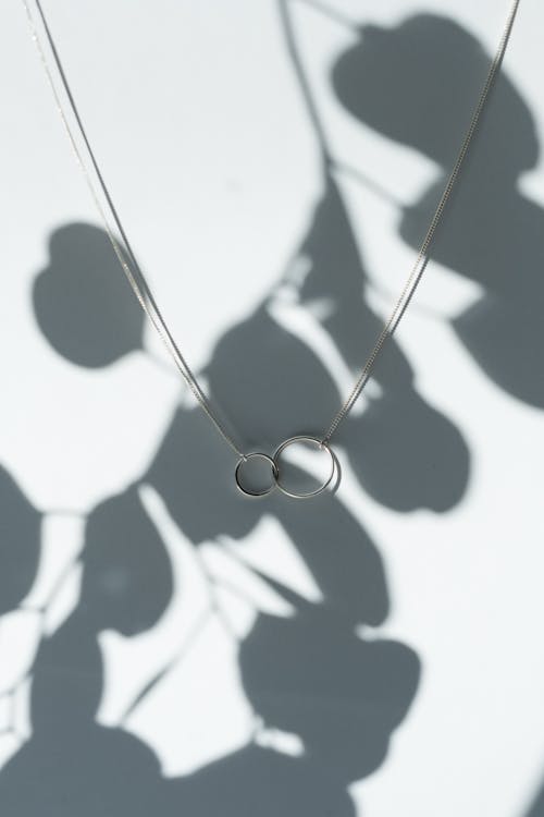 Free Silver Necklace on White Surface with Shadow Stock Photo