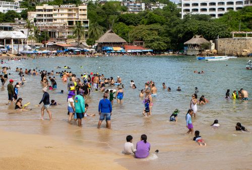 Free A lively day at the beach in Acapulco, Mexico with numerous people enjoying the sea and sun. Stock Photo