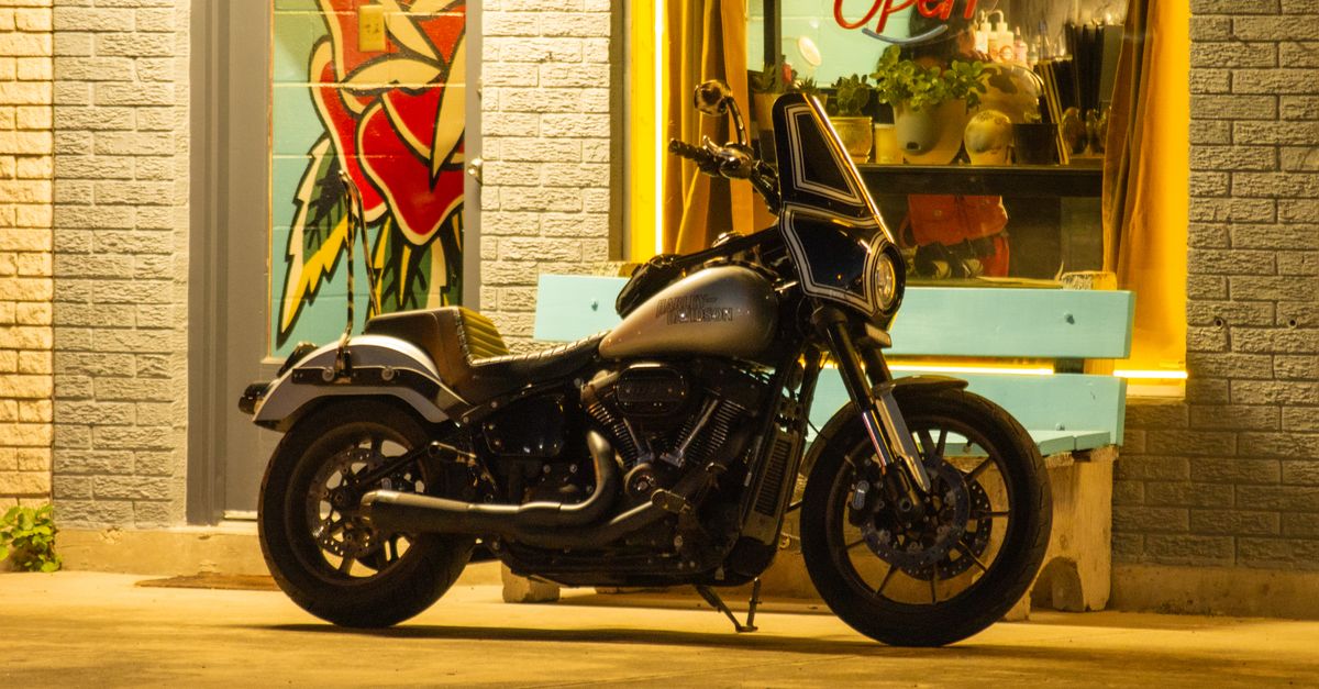 Vintage motorcycle parked outside a lit shop in Edinburg, TX, under warm night lights.