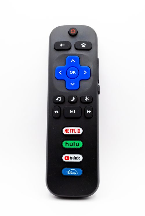 Free Close-up image of a universal remote control featuring Netflix, Hulu, YouTube, and Disney+ buttons. Stock Photo