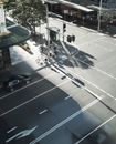 在悉尼一个繁忙的城市十字路口，阳光明媚的日子里，行人和车辆被从上方捕捉到