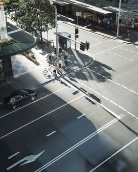 在悉尼一个繁忙的城市十字路口，阳光明媚的日子里，行人和车辆被从上方捕捉到