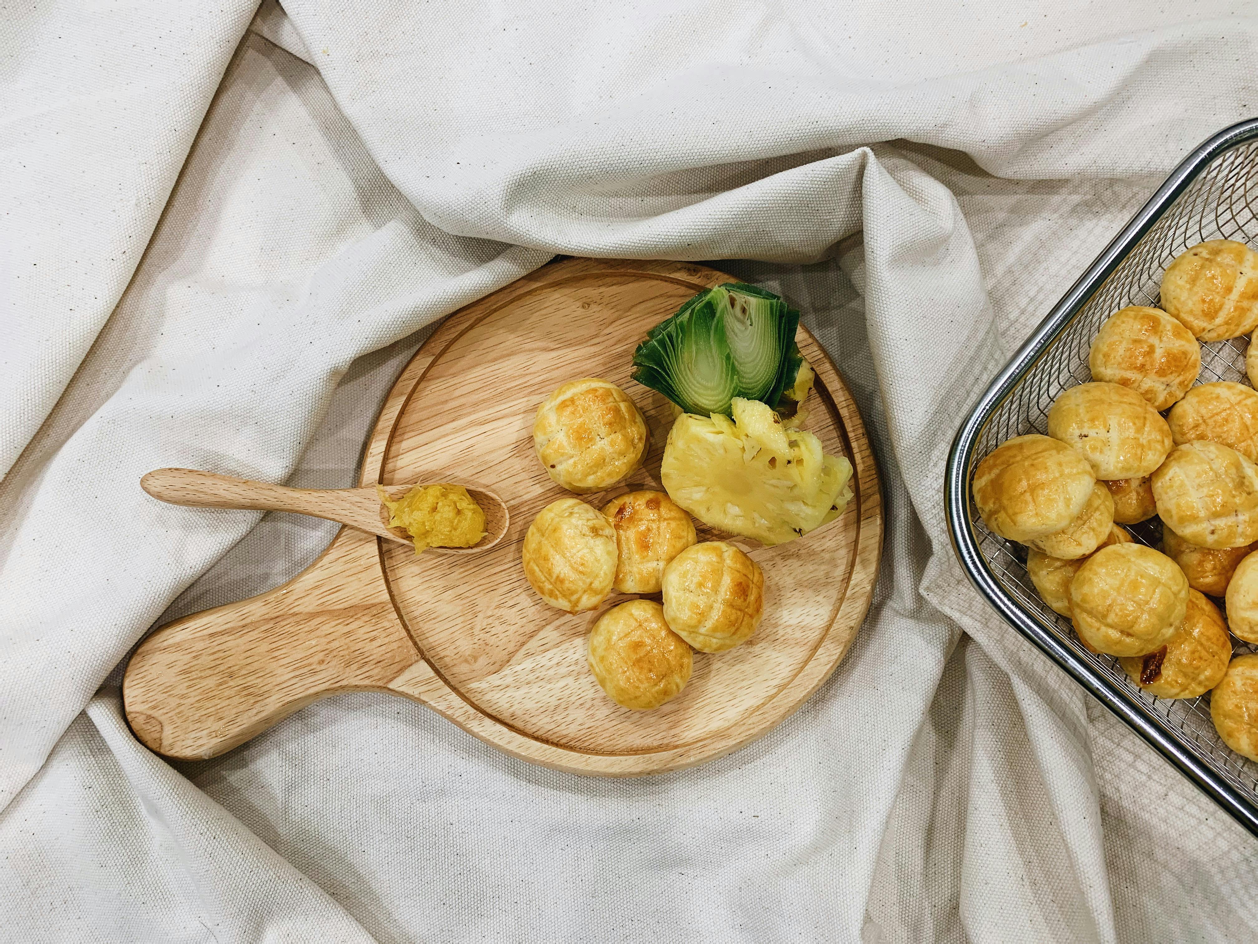 Breads and Pineapple Slice on Brown Wooden Board · Free Stock Photo