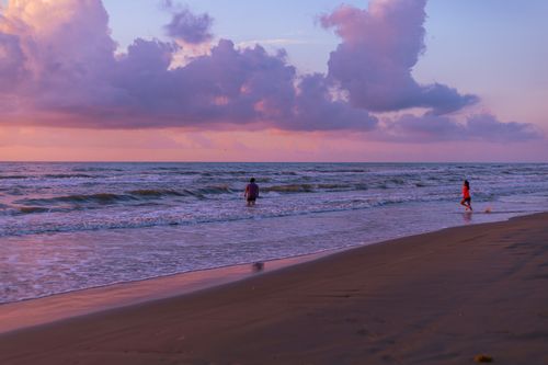 Free Serene sunset view on the beach in Heroica Matamoros with people enjoying the water. Stock Photo