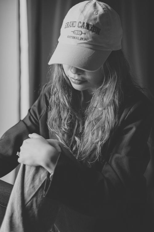 Free A thoughtful woman in a Grand Canyon cap captured in a serene black and white portrait. Stock Photo