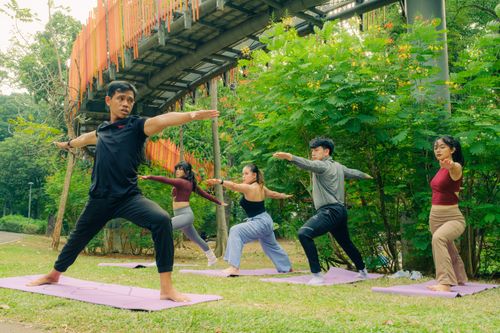 Free Dive into a peaceful group yoga session in a scenic park under a unique metal structure. Stock Photo