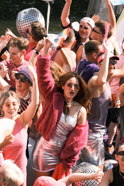 Free Crowd celebrating at Amsterdam Canal Parade with colorful outfits and festive energy. Stock Photo