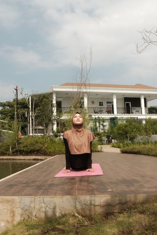 Free Woman practicing yoga outdoors on a sunny day in a peaceful garden. Stock Photo