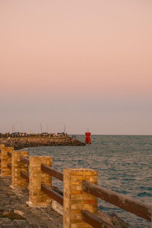 Free Tranquil sunset view of the coastal pier in Rio Grande do Norte, Brazil, with a glowing pink sky. Stock Photo