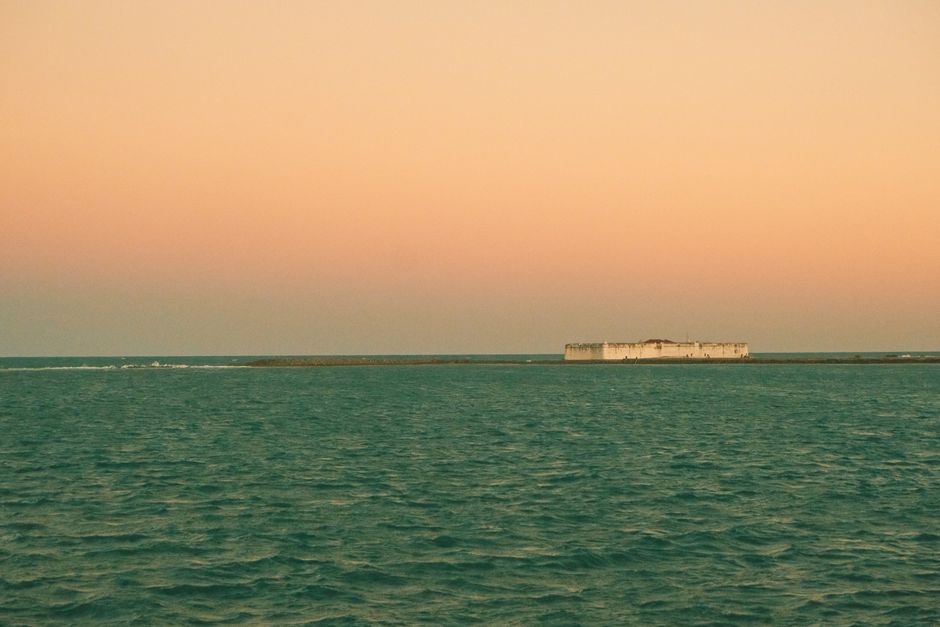 Serene view of Forte dos Reis Magos in Natal, Brazil, under a pastel sunset sky.