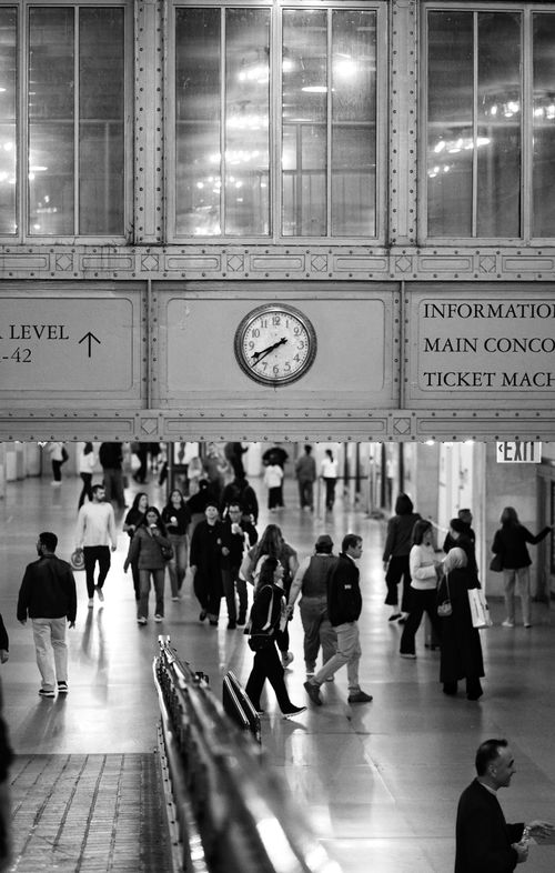 Free Black and white scene of people walking in a busy train station's main concourse. Stock Photo