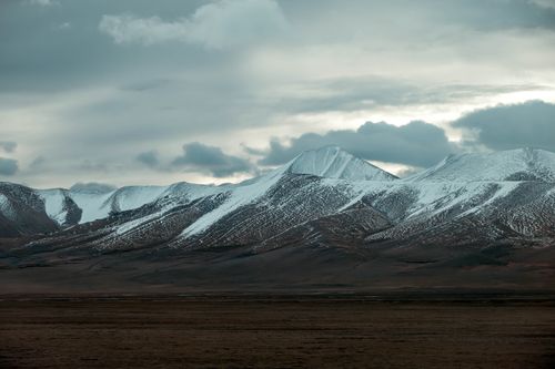 Free Scenic view of snow-capped mountains beneath a cloudy sky, providing a dramatic landscape. Stock Photo
