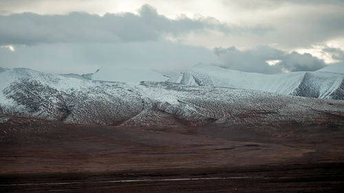 Free Captivating view of snow-covered mountains under moody clouds in a serene setting. Stock Photo