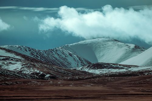 Free A breathtaking view of snow-covered mountains under cloudy skies, capturing the essence of winter wilderness. Stock Photo