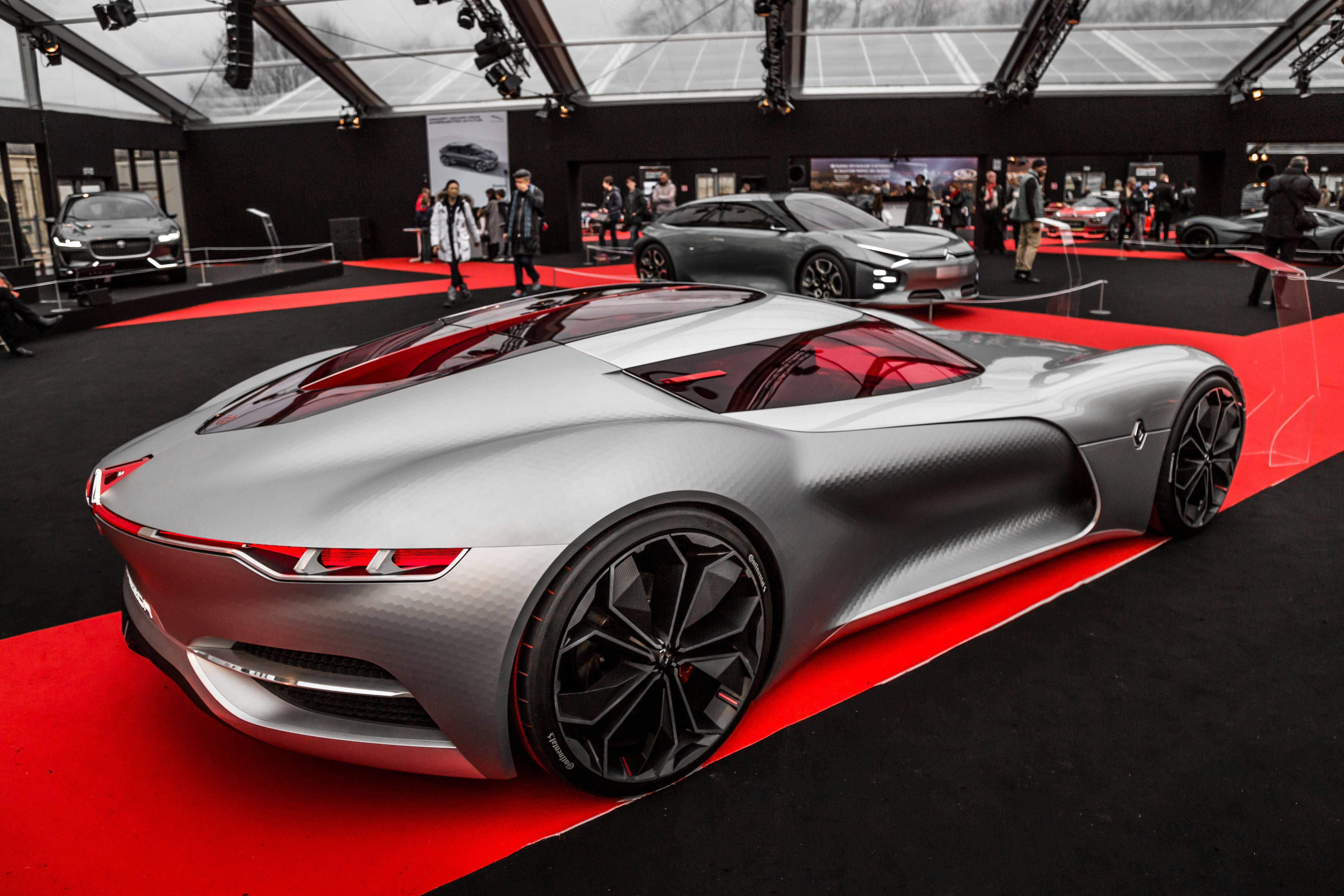 Silver sports car on display at an indoor automotive exhibition.