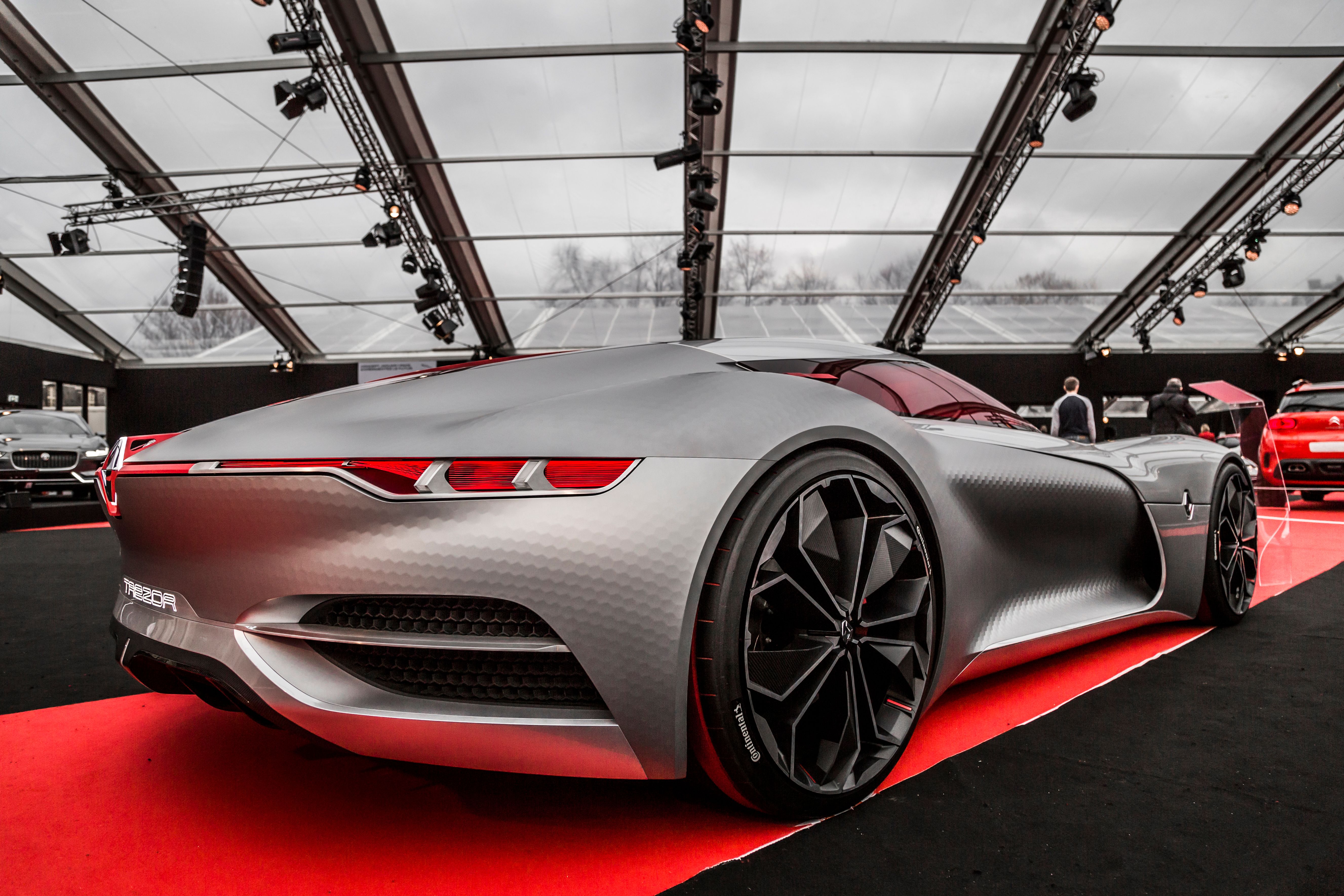 Futuristic concept car in an indoor exhibition hall under dramatic lighting