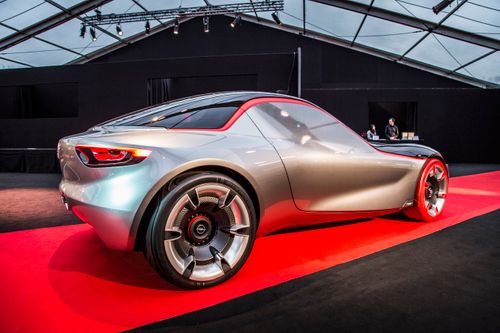 Free A sleek silver concept car displayed under a large indoor pavilion with elegant lighting. Stock Photo