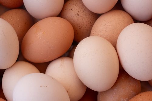 Free A detailed close-up of fresh brown and white eggs in a basket, ideal for food-related themes. Stock Photo