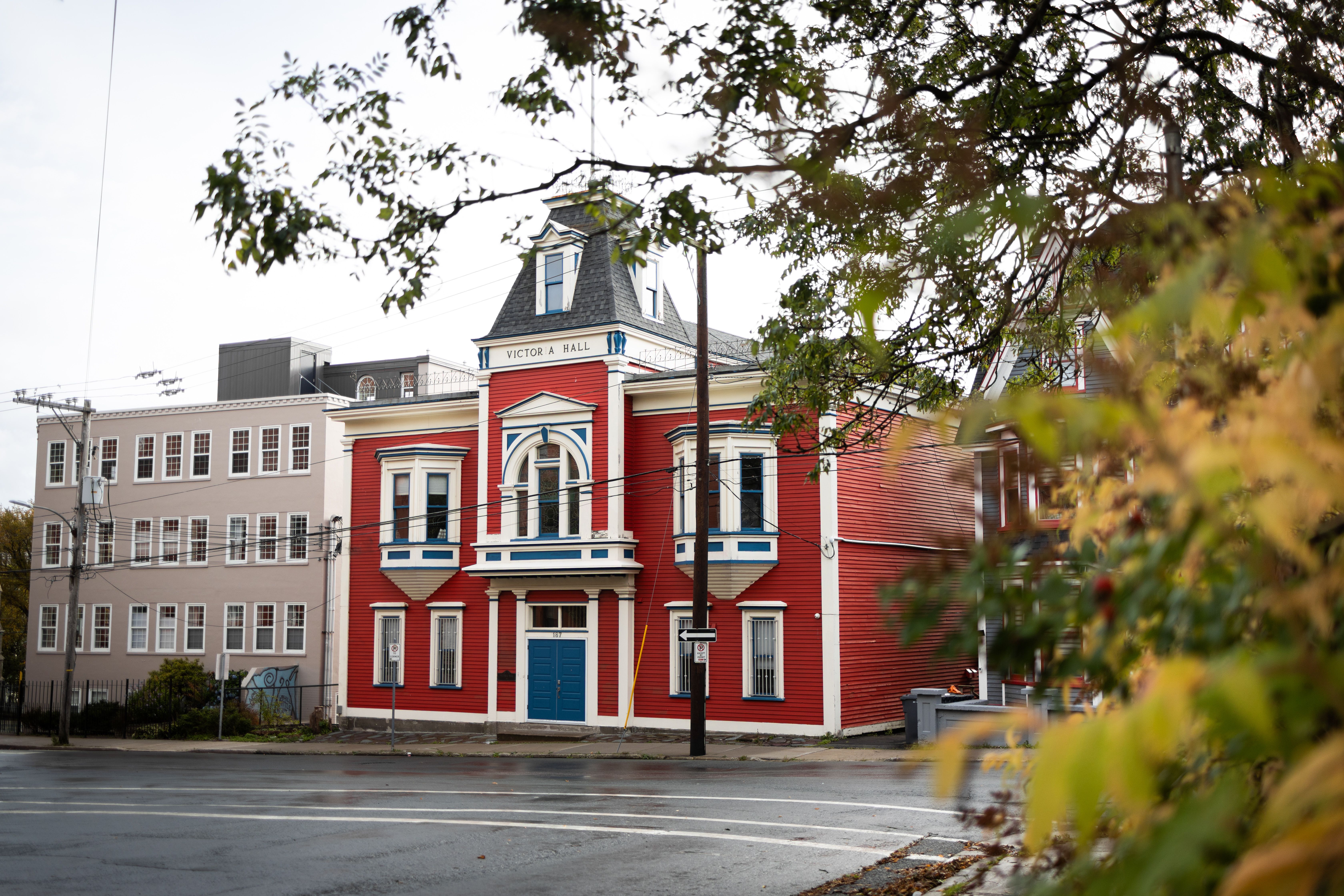 Beautiful red historic building with striking blue accents, showcasing unique architectural design in an urban setting.
