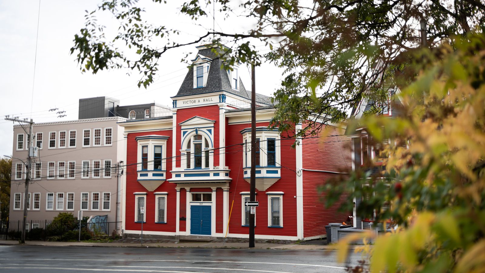 Beautiful red historic building with striking blue accents, showcasing unique architectural design in an urban setting.