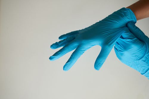 Free Hands wearing blue latex gloves, representing hygiene and safety. Stock Photo