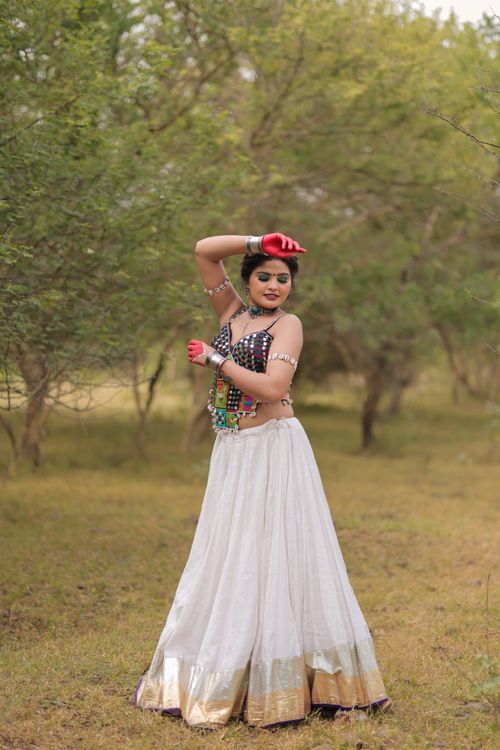 Free Woman in colorful traditional dress posing gracefully in nature. Stock Photo