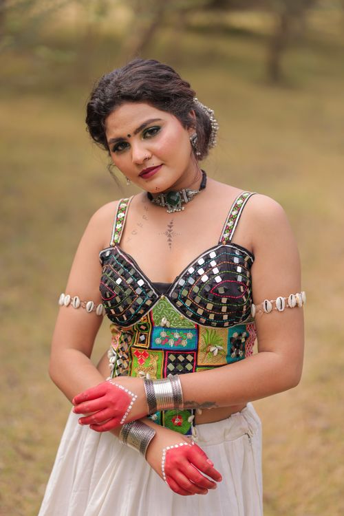 Free A woman in vibrant Indian traditional mirrorwork attire, outdoors, smiling. Stock Photo