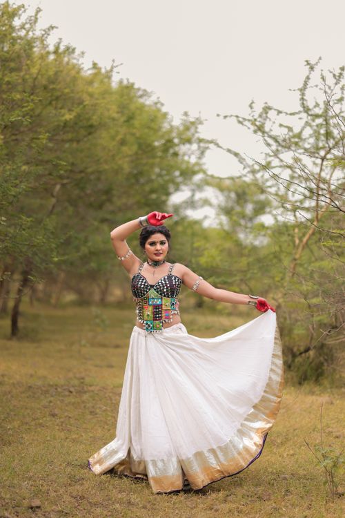 Free Woman in traditional attire poses gracefully outdoors. Stock Photo