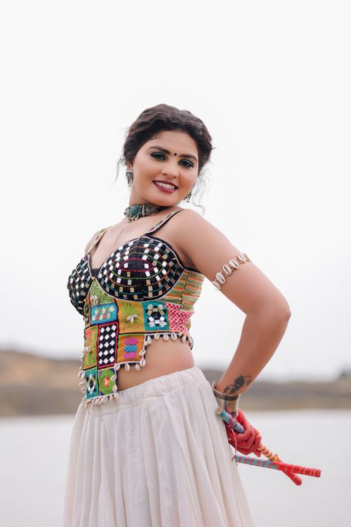 Free Woman in colorful traditional attire posing outdoors with white background. Stock Photo
