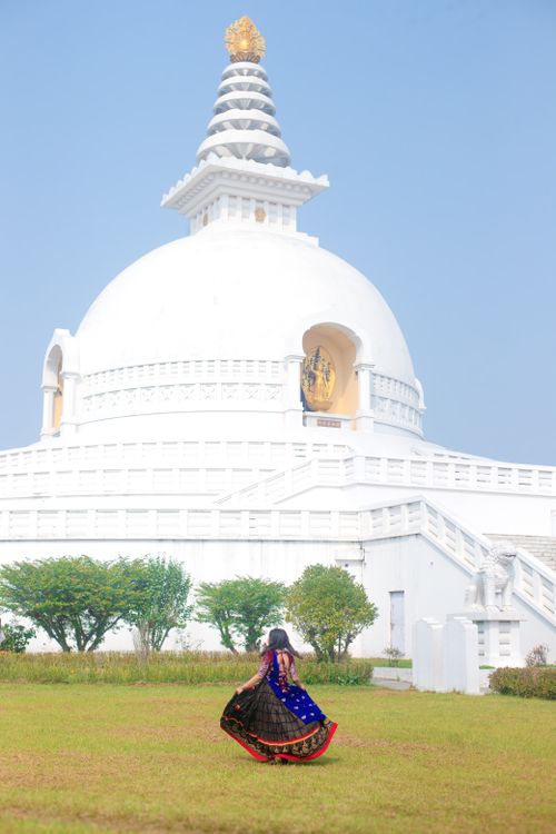 Free A woman in traditional attire stands near a stupa in Lumbini, Nepal. Stock Photo