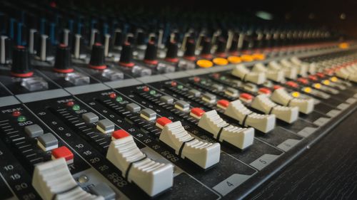 Free Close-up view of a professional audio mixing console with sliders and controls. Stock Photo