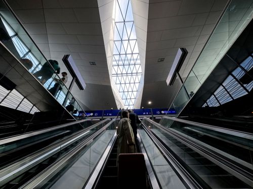 Free A perspective view of people on an escalator at a modern train station in Vienna. Stock Photo
