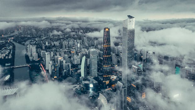 Breathtaking aerial shot of the Guangzhou cityscape cloaked in clouds, showcasing modern skyscrapers.