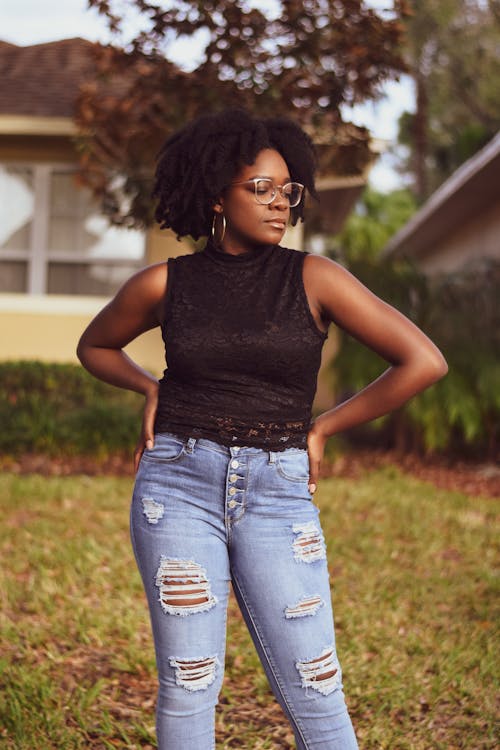 Woman In Black Top And Blue Denim Jeans Standing On Lawb